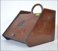 A 20th century oak coal scuttle having a brass handle atop, lift up front with decorative carvings.