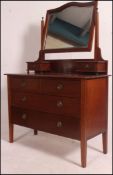An Edwardian mahogany dressing table raised on squared legs with a series of drawers having swing
