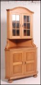 A 20th century continental country oak corner cabinet raised on bell feet with cupboards under