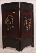 A 19th century Japanese laquered and inlaid two fold discretionary screen with fret work panel tops