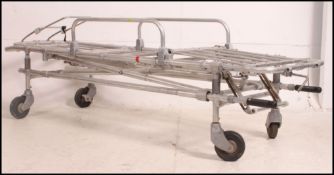 A retro 20th century hospital gurney - trolley bed of stainless steel construction with metamorphic