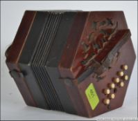 An 20th century squeezebox of mahogany construction with fret pierced ends with leather and cloth