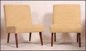 A pair of Retro 20th century square back side chairs having clean upholstered covers raised on