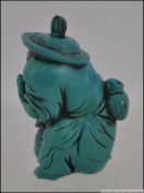 An unusual 20th century Turquoise figural snuff bottle of a man holding a fish. Measures: 6cms high.