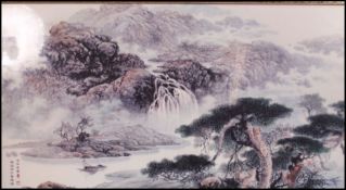 A very large 20th century Chinese framed ceramic tile transfer printed with mountain scenes having