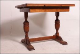 A 1930's Art Deco oak draw leaf refectory dining table raised on cup and cover supports having