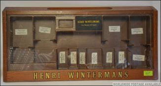 A vintage Henri Wintermans cigar shop display cabinet having glass door with sectional interior