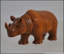 A carved hardwood netsuke in the form of a rhinoceros. Measures: 6cms long.