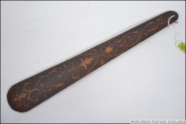 A Victorian poker work page turner / paper knife of tapering form being decorated on both sides