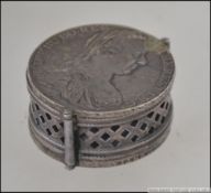 A unusual silver metal pill pot / coin purse having a fret pierced hinged side slide and two