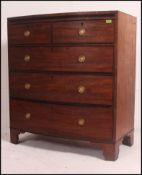 A late Georgian mahogany bow front two over three chest of drawers raised on splayed bracket feet,