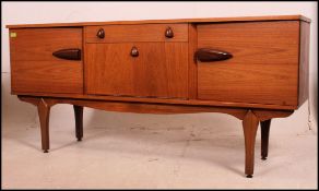 A 1970's Danish style retro teak wood sideboard raised on tapered supports having fall front