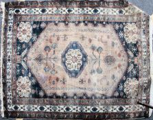 An early 20th century Persian rug with beige and blues having central medallion,