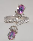 A ladies silver dress ring adorned with mystic topaz suspension setting. Total weight 6.5g / Size m.
