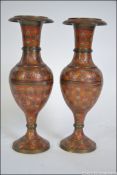 A pair of enamel painted engine turned Indian Gu style vases.