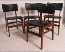 4 vintage framed teak dining chairs having black faux leather padded seats and back rests