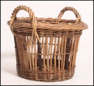 A vintage whicker basket in the manner of a Grimsby fishing basket ideal for log storage