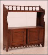 A Victorian mahogany hanging bookcase cabinet having twin cupboard doors with open shelf atop.