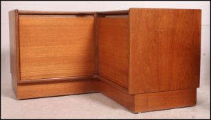 A 1960's 70's vintage Danish influence teak low corner unit of L-shape being raised on an inset