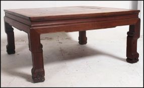 A Chinese hardwood coffee table of square form with reentrant corners on moulded legs.