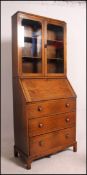 A 1930's golden oak students bureau bookcase. The glass cabinet over bureau beneath.