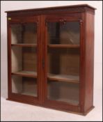 A Victorian mahogany display cabinet having twin glass doors with shelved interior,