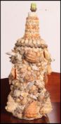 A vintage / retro large whisky bottle converted into a table lamp having applied shell work and