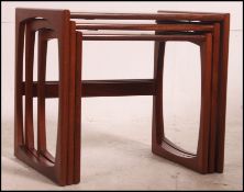 A 1970's retro G-Plan Kelso nest of tables being raised on squared legs with peripheral stretchers,