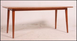 A 1970's Danish teak wood coffee table being raised on tapered legs with chamfered edge top.