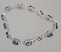 A ladies contemporary silver and London blue topaz bracelet,