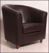 A contemporary dark brown leather tub chair by Marks & Spencers being raised on block feet.