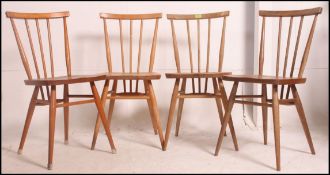 A set of 4 Ercol beech and elm dining chairs having turned legs with upper peripheral stretchers,