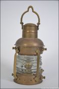An early 20th century brass ships navigational light with cage protective bars,