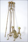 A set of Georgian style brass fireside companions along with a pair of brass fire dogs.
