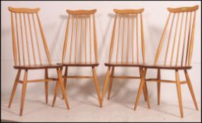 A set of 4 Ercol beech and elm Goldsmiths dining chairs with railed back rests over saddle seats