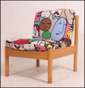 A vintage Ercol 741 lounge chair of beech wood form marked to base having abstract face cushions (