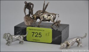 A miniature silver and marble diorama of a matador and bull together with 2 miniature white metal