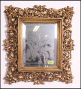 An early 20th century gilt plaster molded framed bevel edged mirrror being adorned with acorns and