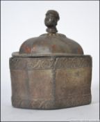 A 19th century unusual heavy lead casket of octagonal form with tribal head finial,