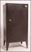 A large 1950's green Industrial military metal stationary locker cupboard having a single door