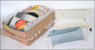 A collection of assorted vintage vinyl record singles, along with two retro design record stands.