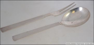 A mid century Georg Jensen Sterling Silver marked serving spoon and fork in the Bernadotte Pattern.