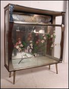 A retro 1950's china display cabinet having mirror lined interior with mirror uprights,