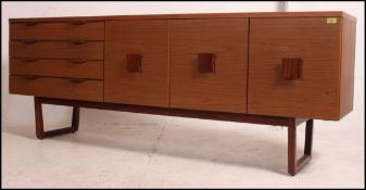 A retro 1970's seven foot teak effect sideboard having a run of three drawers alongside a drop down