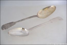 2 Georgian 19th century silver hallmarked table serving spoons, bth monogrammed to handles.