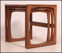 A retro 1970's G-Plan Kelso Nest of table in teak raised on squared supports having graduating tops