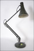 A 20th century retro Herbert Terry Anglepoise lamp in green raised on a circular base.