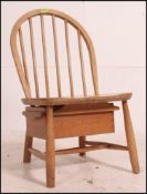 An Ercol Golden Dawn spindle backed nursing chair with drawer below.