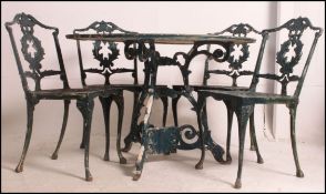 A Victorian style cast five piece garden furniture set comprising of a large circular topped table,