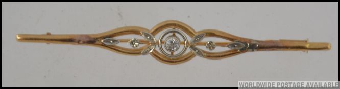 A 9ct gold and diamond bar brooch with central stone approx 10pnts with floral inset surround,
